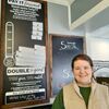 Kenna Bogue, General Manager of the Mark Twain Dinette, stands with the Pay it Forward Board where certificates purchased by customers are placed to help pay for a meal for someone in need.